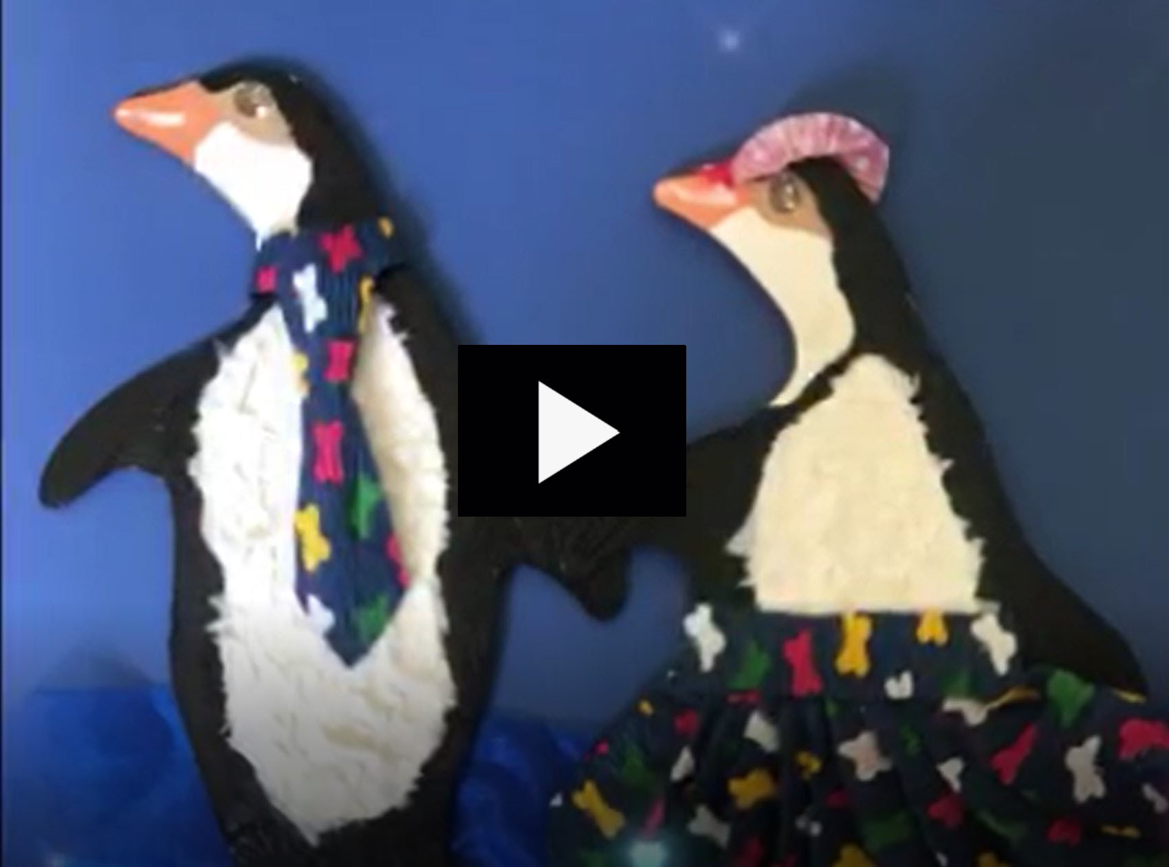 immagine delle sagome di due pinguini decorati dagli alunni che apre il link al video con testi in italiano